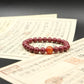 Red Cinnabar beaded bracelet, Emotional Balance, on top of an old document with a dark background