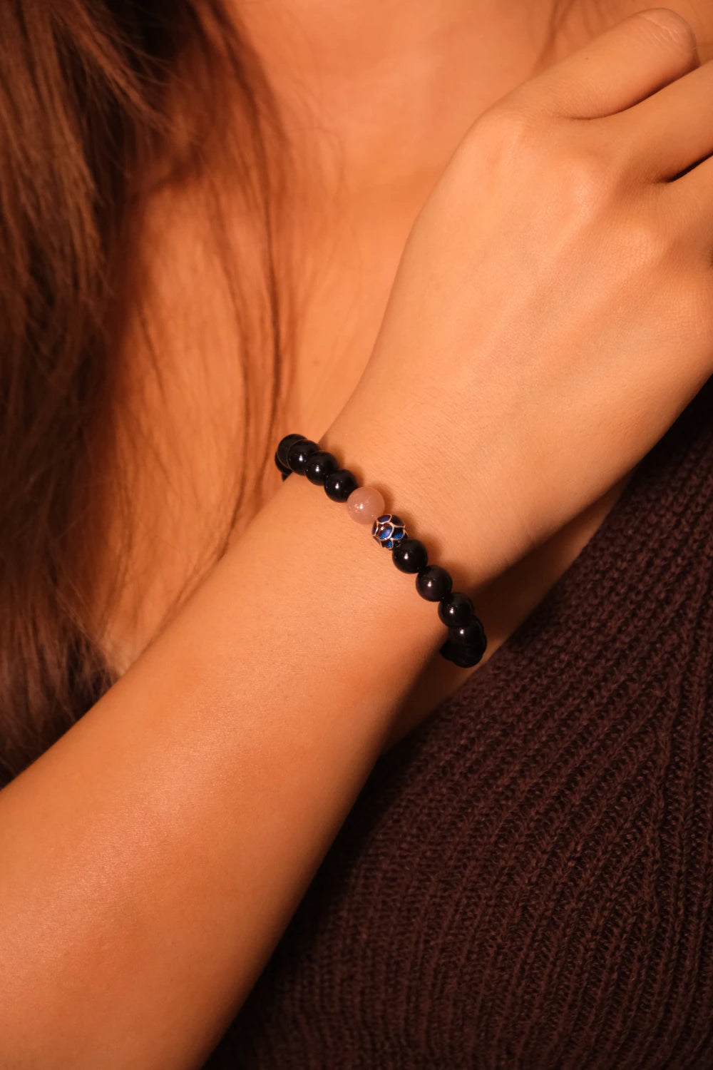 Close-up of a person's wrist wearing a Tibetan Meditation black beaded bracelet.