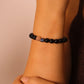 Close-up of a wrist wearing a Tibetan Meditation beaded bracelet against a neutral background