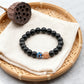 Tibetan style obsidian bracelet featuring natural black obsidian beads and colorful cloisonné bead