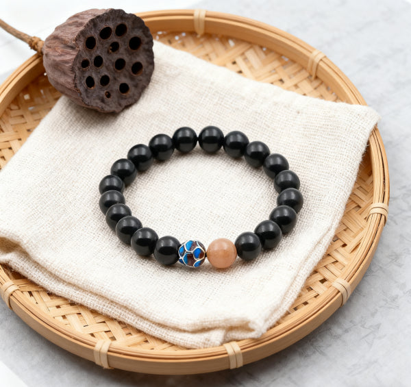 Tibetan style obsidian bracelet featuring natural black obsidian beads and colorful cloisonné bead