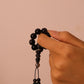 Hand holding Grounding & Protection – Tibetan Meditation Spinner against a beige background