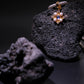 Handcrafted Tibetan Moonstone Pendant Necklace featuring a glowing natural moonstone surrounded by pearls, displayed on volcanic rock, associated with inner calm and emotional harmony.