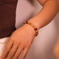 Hand wearing a Tibetan Prosperity Energy beaded bracelet on a blurred background