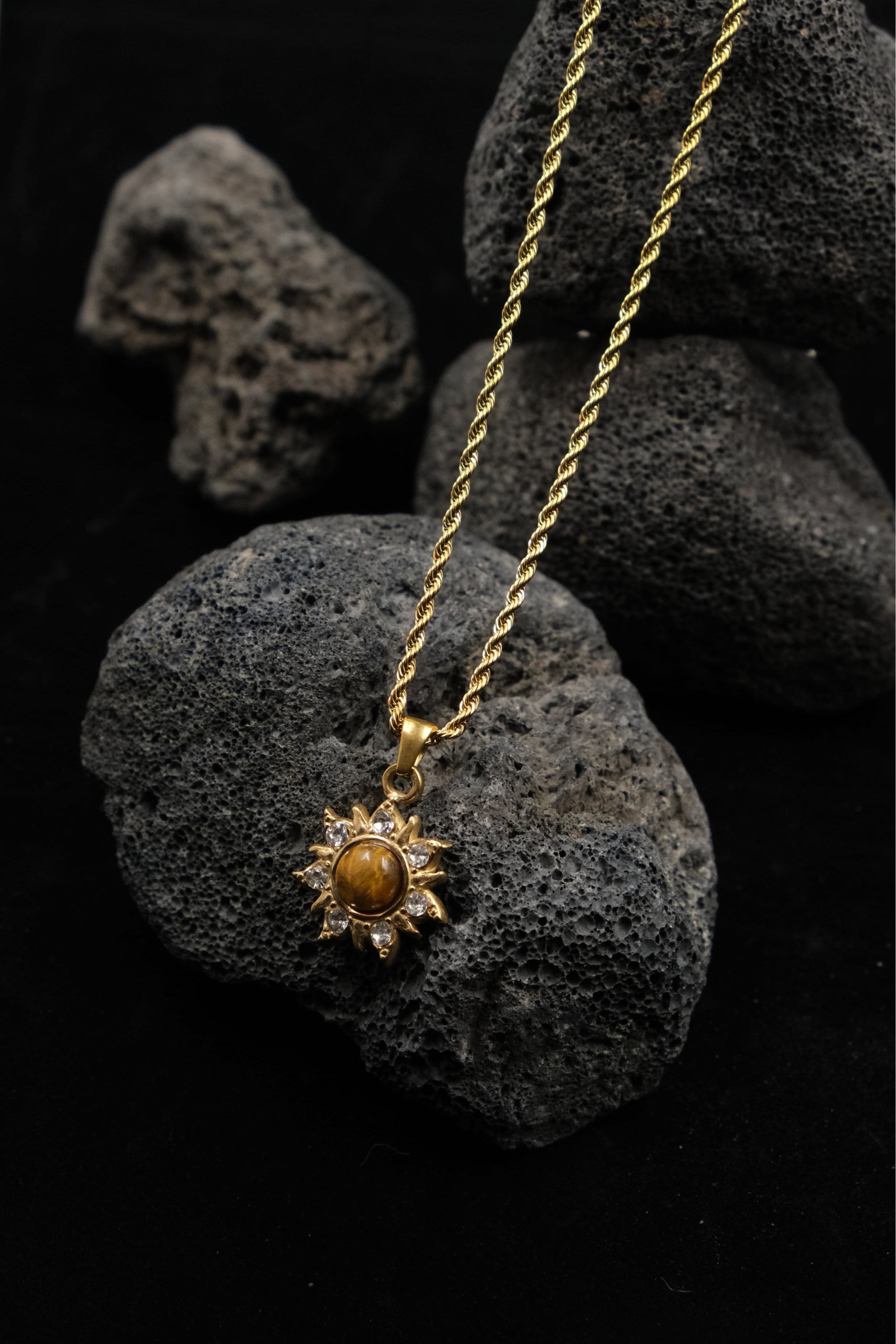 Success & Abundance – Tibetan Sun Pendant with a sun pendant on dark stone background