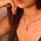 Close-up of a woman wearing a tiger`s eye stoneTibetan Sun Pendant with a pendant against a neutral background