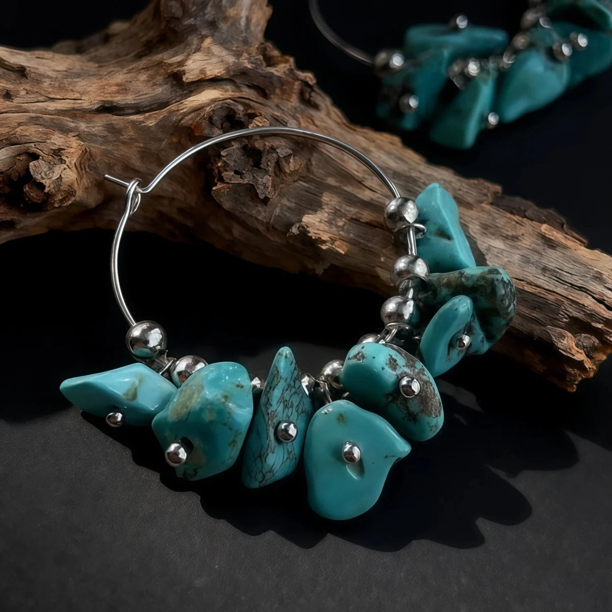 Turquoise beaded earrings on a dark surface with a wooden branch