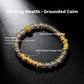 Bracelet with gold-plated elements and gray agate beads on a dark background