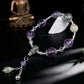 Bracelet with purple beads and silver accents on a dark background