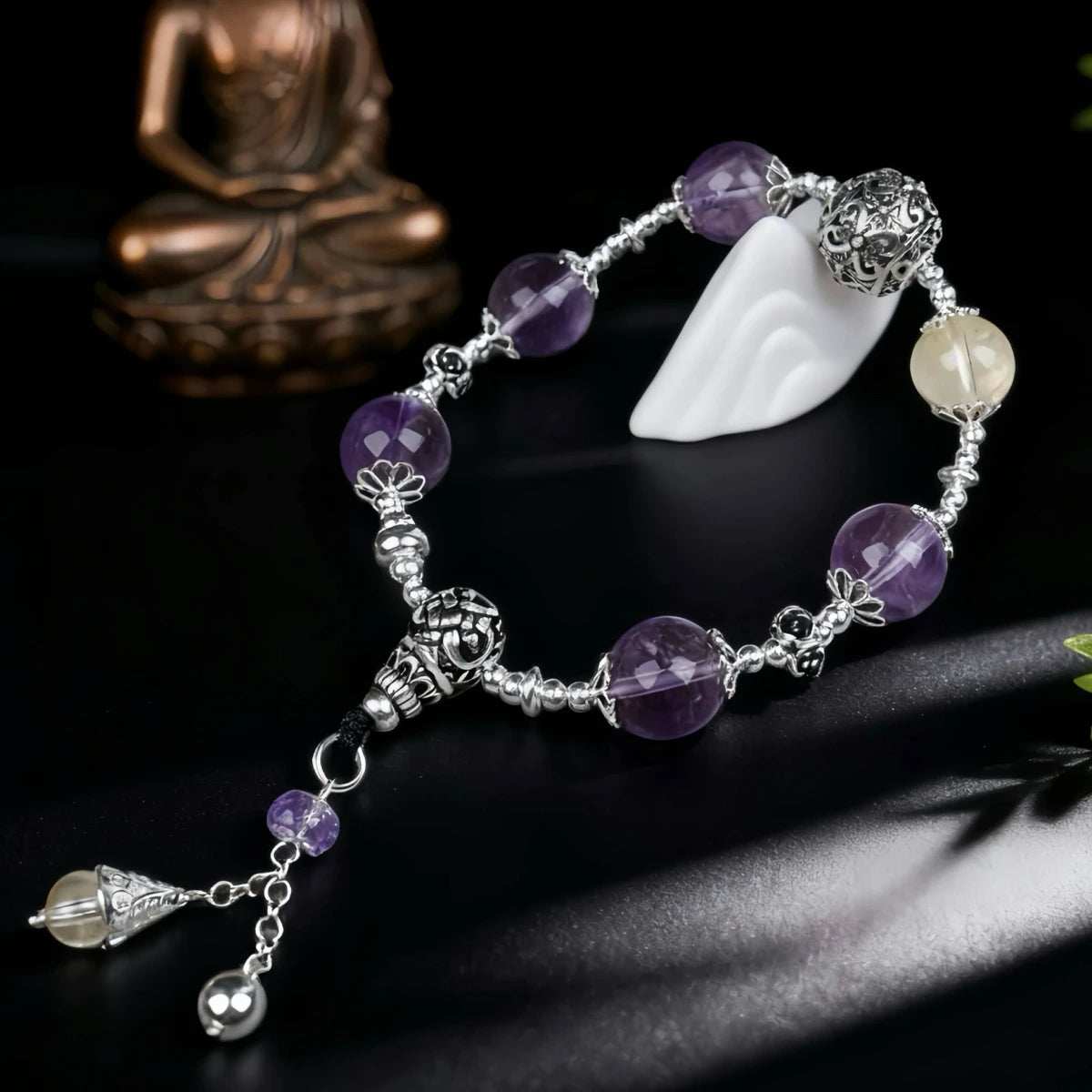 Bracelet with purple beads and silver accents on a dark background