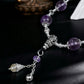 Purple beaded necklace with silver accents on a dark background
