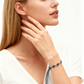 Woman wearing a blue beaded bracelet on a white background