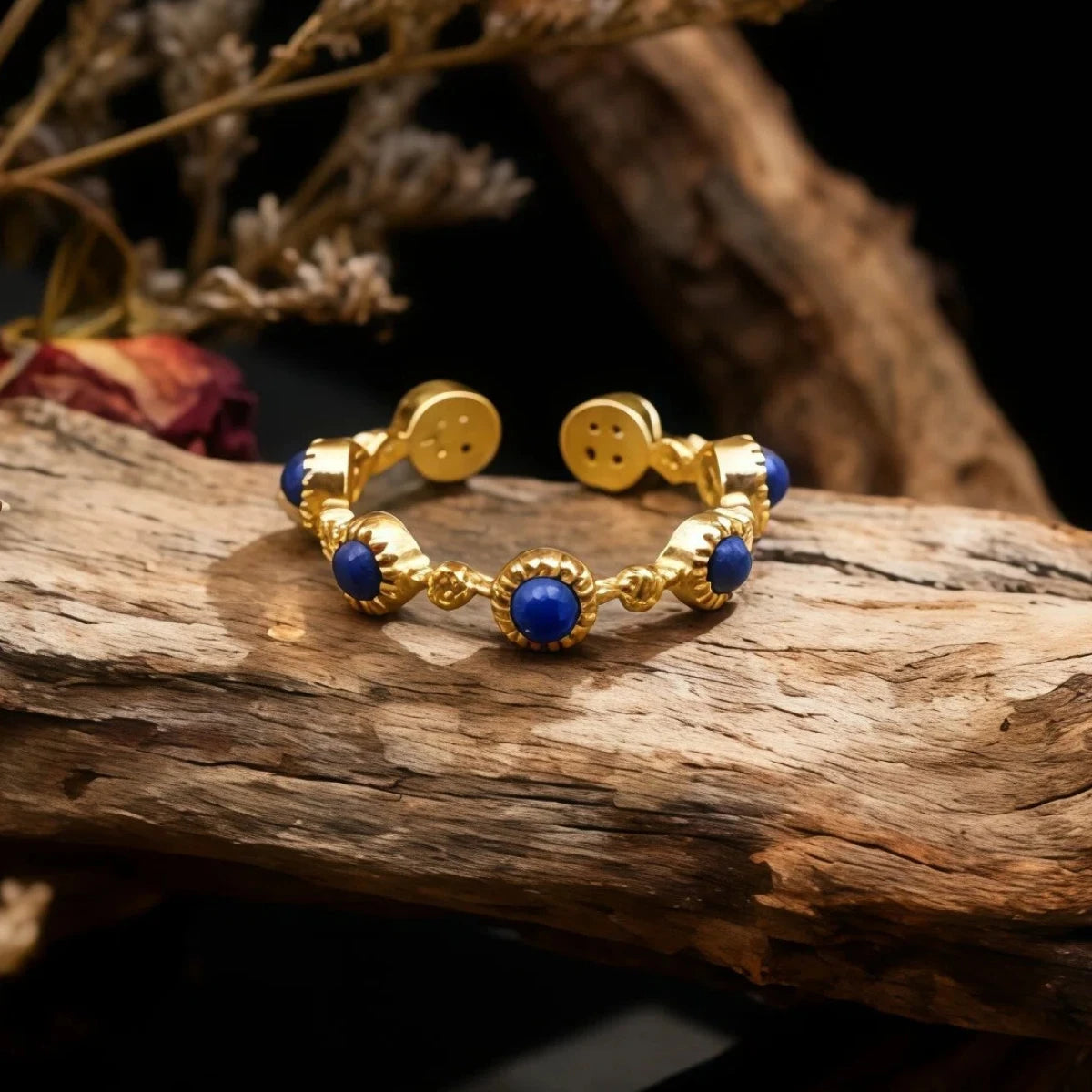 Gold bracelet with Lapis Lazuli beads on a wooden surface