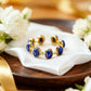 Gold and blue ring on a white napkin with white flowers and gold ribbon