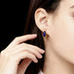 Close-up of a person wearing a gold earring with a blue Lapis_Lazuli_Vintage gemstone on a black background