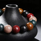 The multi-colored bracelet draped around the neck of a black ceramic vase.